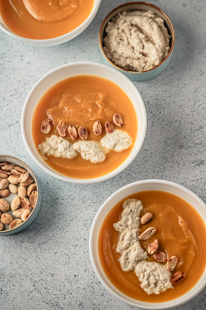 Crème de patate douce à la cacahuète onctueuse servie dans une assiette creuse