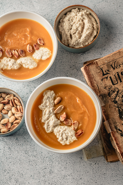 Crème de patate douce à la cacahuète onctueuse servie dans une assiette creuse